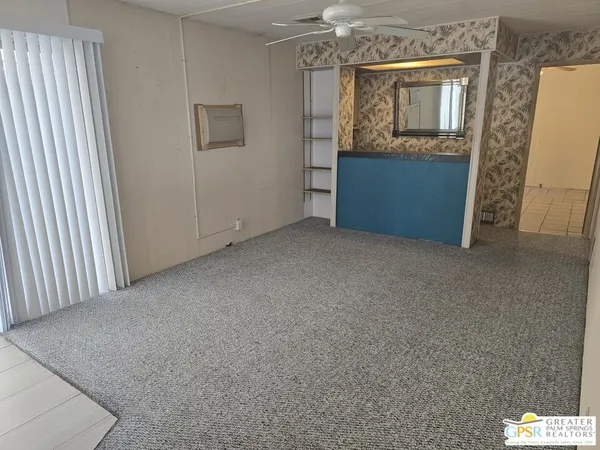 an empty room with window and cabinet