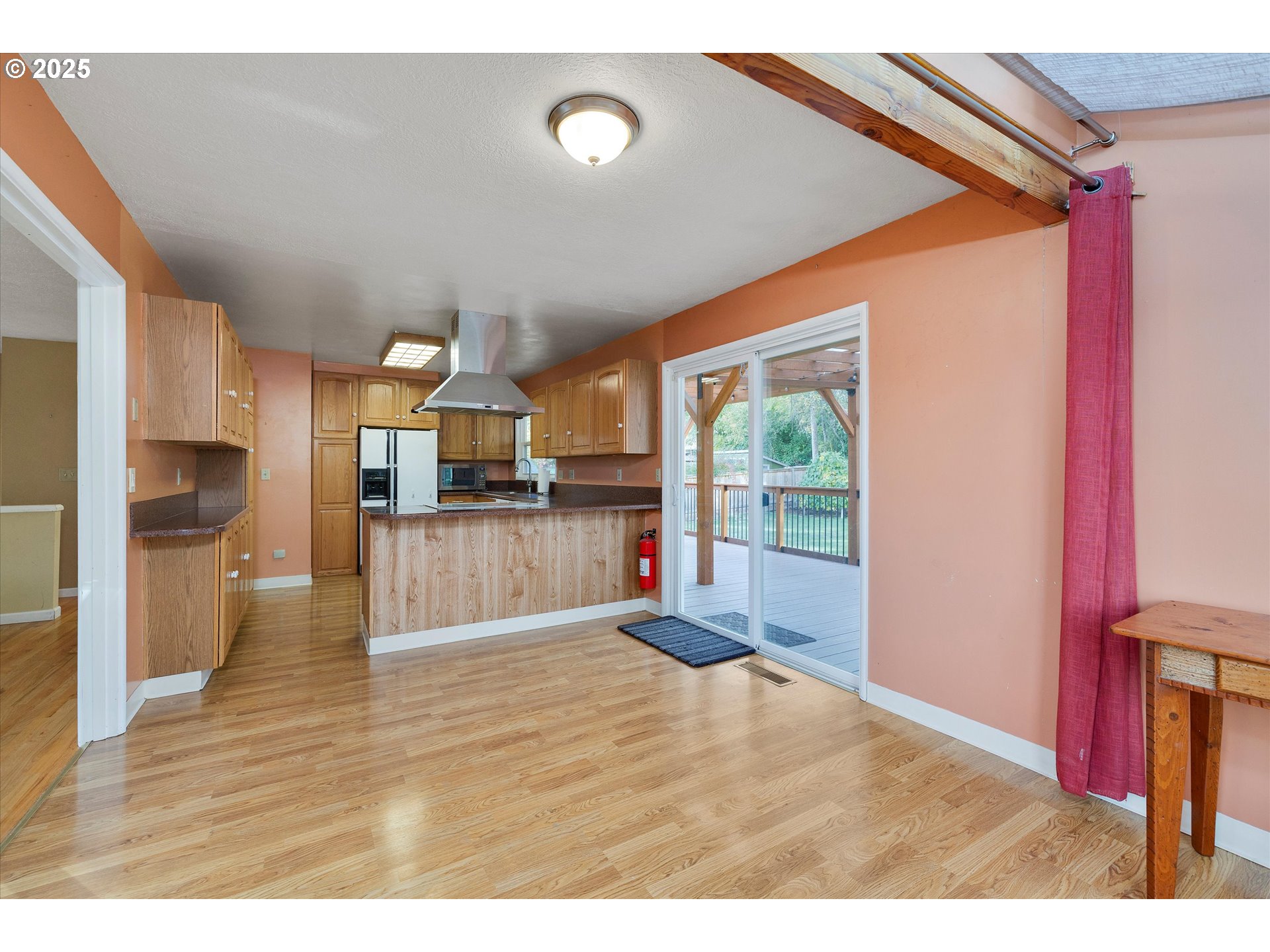 1360 Northwest 130th Avenue Portland, OR 97229 - Photo 13 of 36 a living room with stainless steel appliances kitchen island granite countertop a refrigerator and a wooden floor