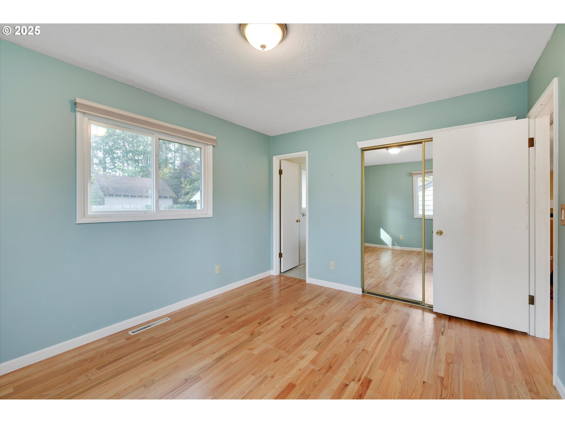 1360 Northwest 130th Avenue Portland, OR 97229 - Photo 22 of 36 a view of an empty room with wooden floor and a window
