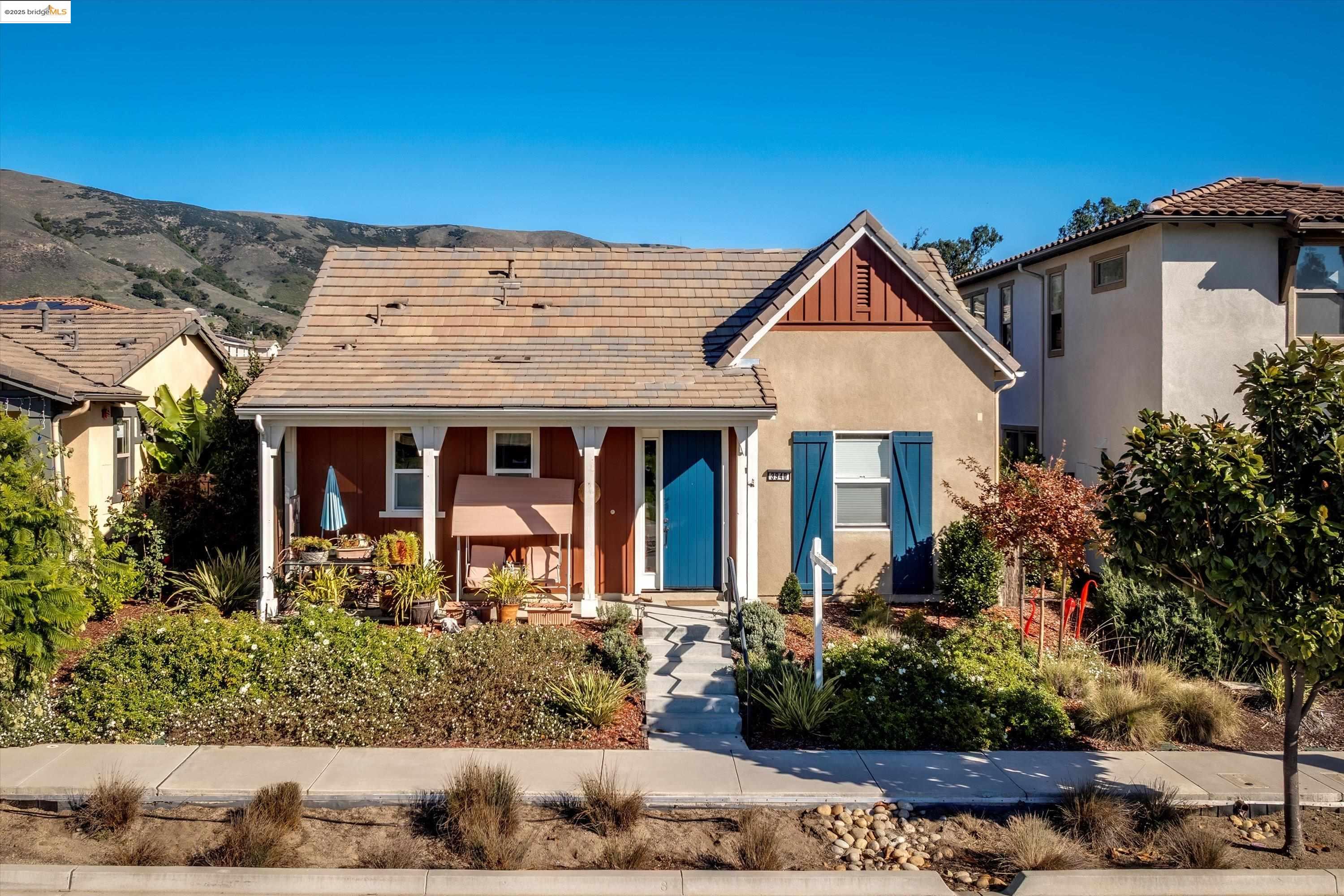 View of front of home featuring covered porch, a tile roof, board and batten siding, and stucco siding
