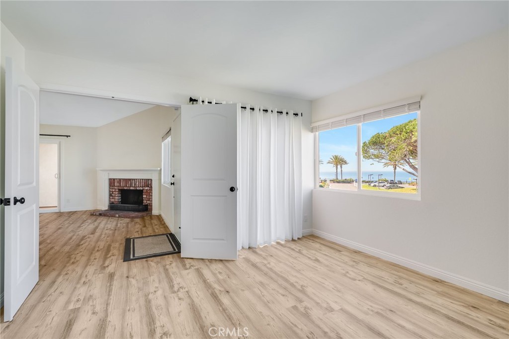 34112 Selva Road, Unit 329 Dana Point, CA 92629 - Photo 16 of 34 wooden floor in an empty room with a fireplace