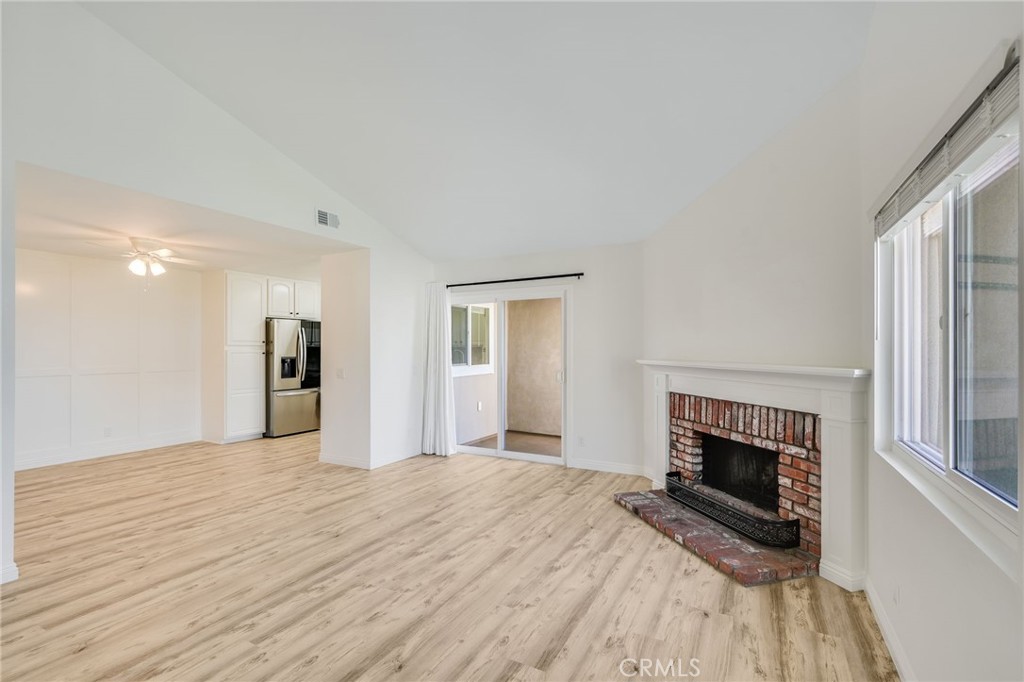 34112 Selva Road, Unit 329 Dana Point, CA 92629 - Photo 5 of 34 a view of empty room with wooden floor and fireplace