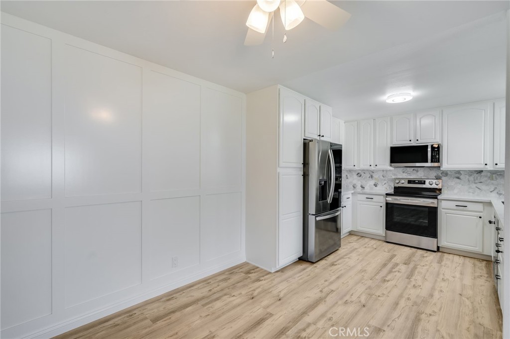 34112 Selva Road, Unit 329 Dana Point, CA 92629 - Photo 8 of 34 a kitchen with granite countertop a refrigerator stove and microwave