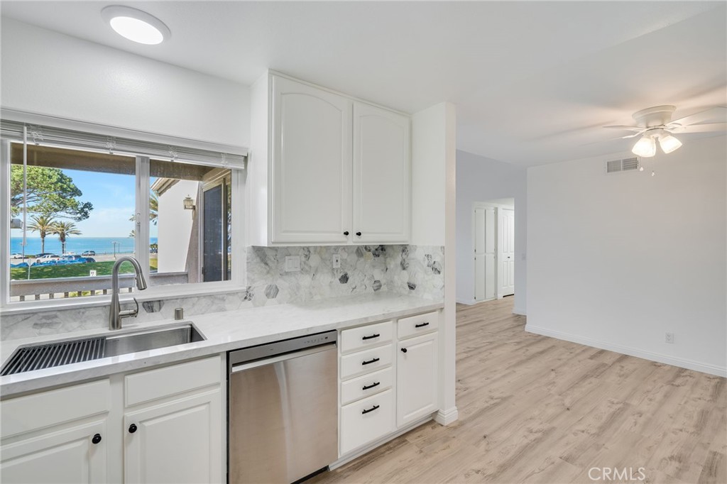 34112 Selva Road, Unit 329 Dana Point, CA 92629 - Photo 9 of 34 a kitchen with granite countertop a sink cabinets and wooden floor