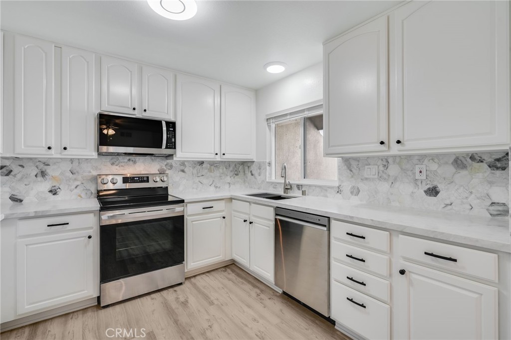 34112 Selva Road, Unit 329 Dana Point, CA 92629 - Photo 10 of 34 a kitchen with granite countertop white cabinets sink and stainless steel appliances
