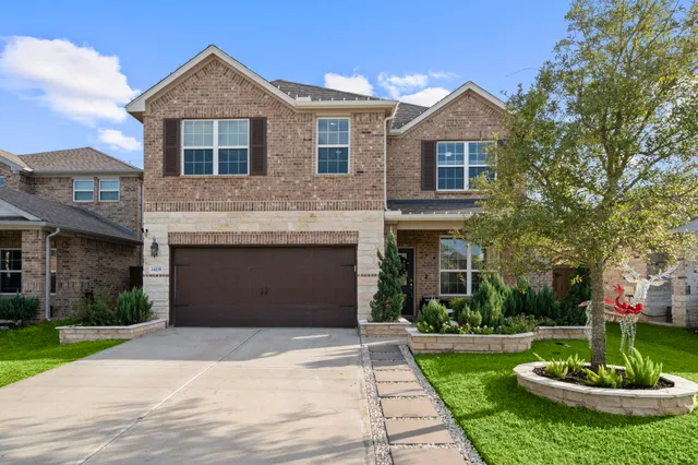 a front view of a house with a yard and trees