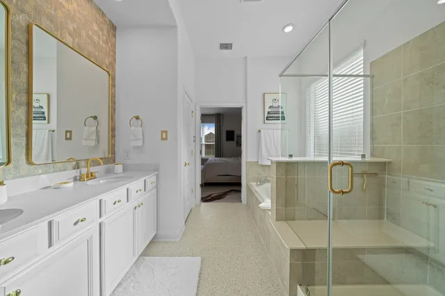 a en suite bathroom with a granite countertop sink a mirror and shower