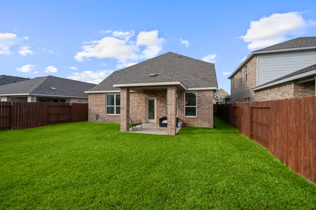 a front view of a house with backyard garden and outdoor seating