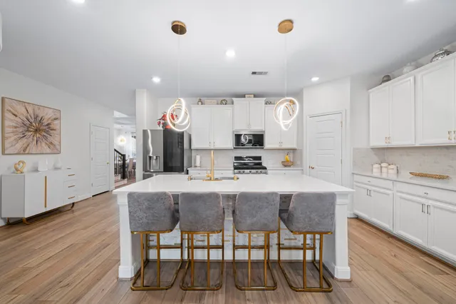 a large kitchen with kitchen island a table and chairs in it