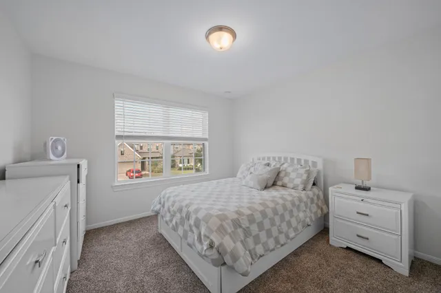 a bedroom with a bed and a window