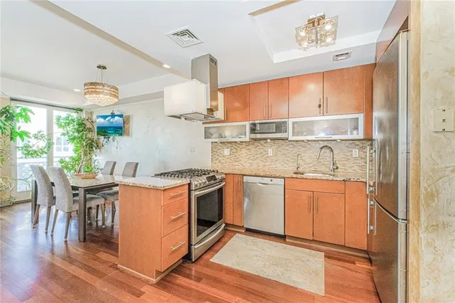 a kitchen with stainless steel appliances granite countertop a stove and a refrigerator