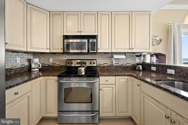 a kitchen with granite countertop white cabinets and appliances