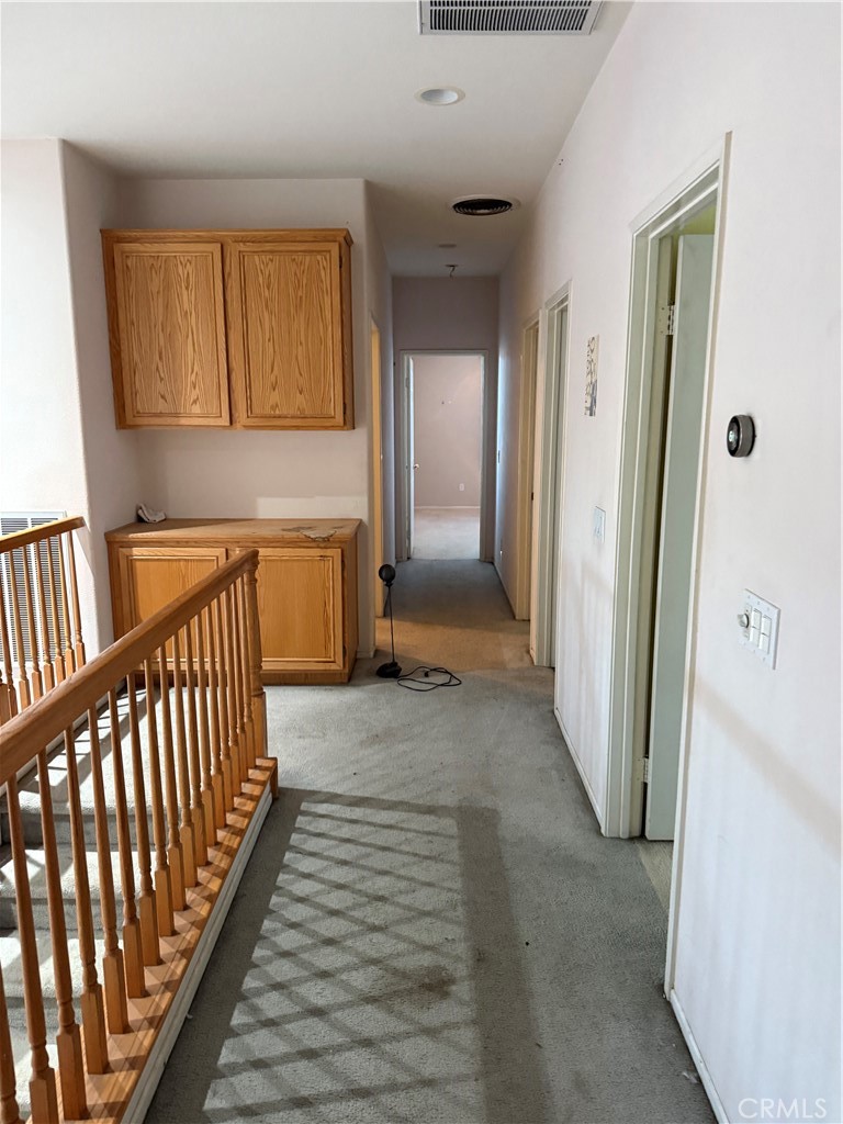 13571 Canyon Crest Way Eastvale, CA 92880 - Photo 19 of 23 a view of a hallway with wooden floor and a bathroom