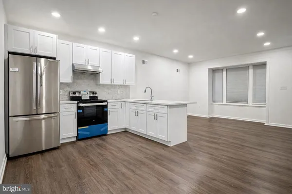 a kitchen with stainless steel appliances a refrigerator sink and cabinets