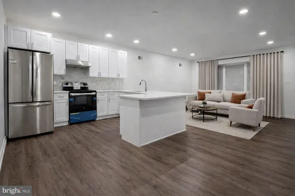 a kitchen with stainless steel appliances granite countertop a refrigerator and a stove top oven
