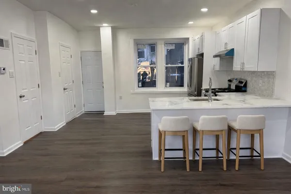 a view of kitchen with granite countertop cabinets table and chairs