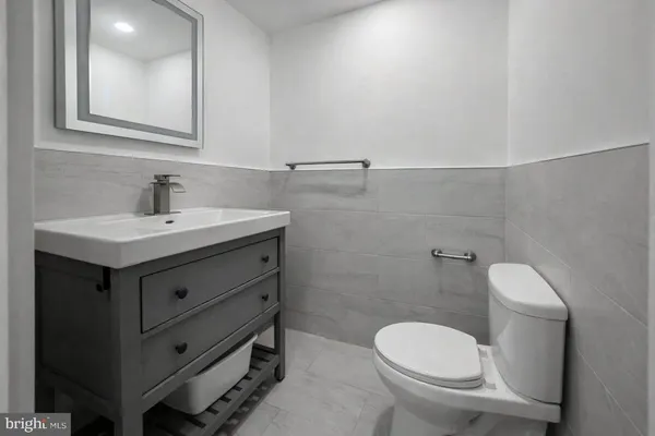 a bathroom with a toilet a sink and mirror