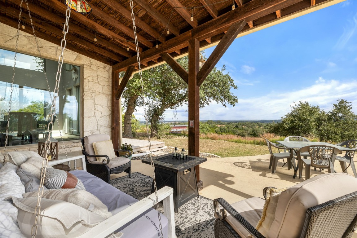 3108 Rolling Hills Road Blanco, TX 78606 - Photo 29 of 39 a view of a patio with couches chairs dining table and chairs with wooden floor