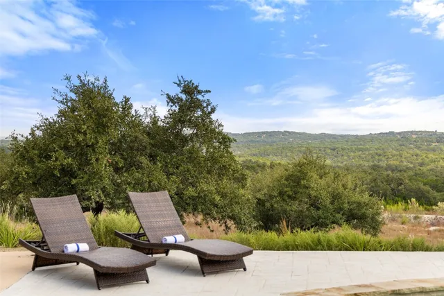 a view of a patio with lawn chairs