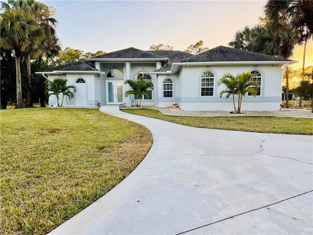 a view of a house with backyard and a tree