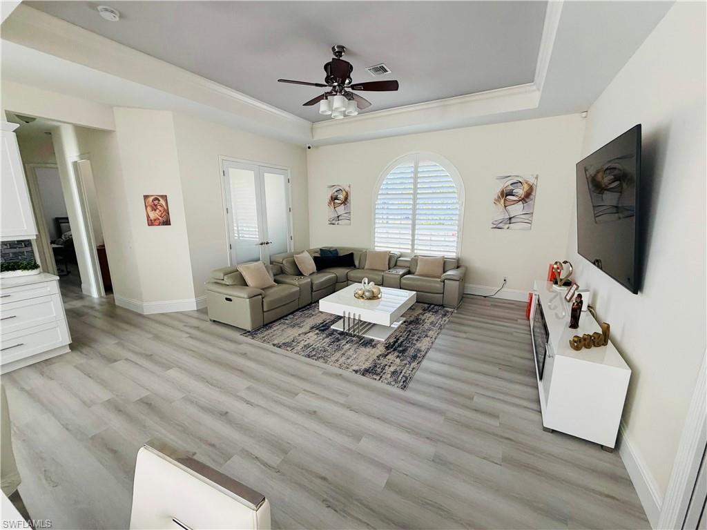 3960 1st Avenue Northwest Naples, FL 34119 - Photo 12 of 25 a living room with furniture a flat screen tv and a large window