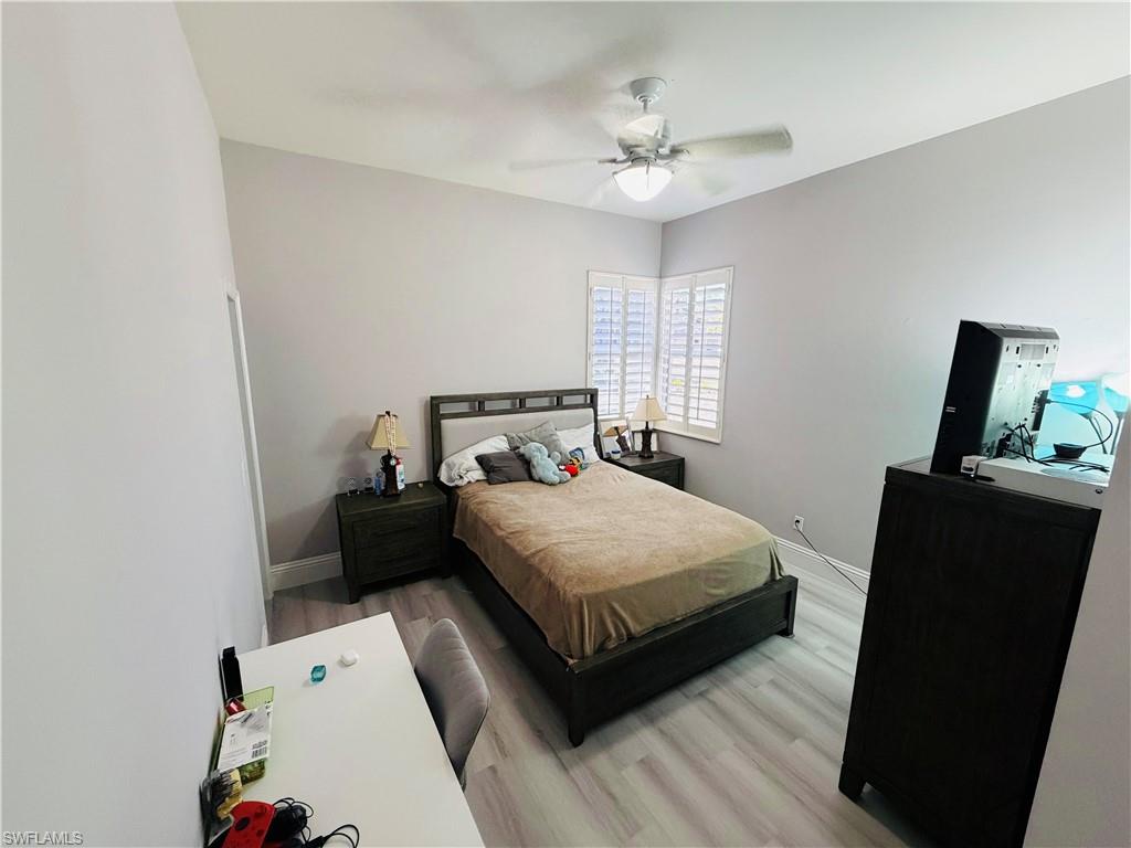 3960 1st Avenue Northwest Naples, FL 34119 - Photo 20 of 25 a bedroom with a bed and wooden floor