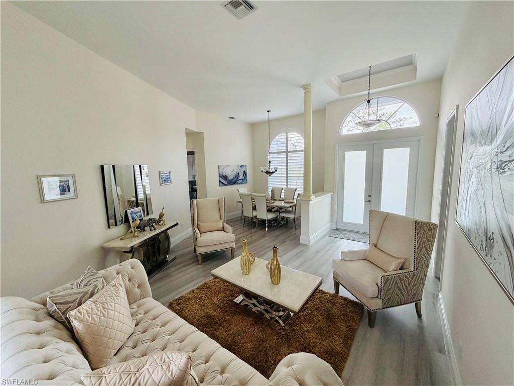 3960 1st Avenue Northwest Naples, FL 34119 - Photo 7 of 25 a living room with furniture and a chandelier