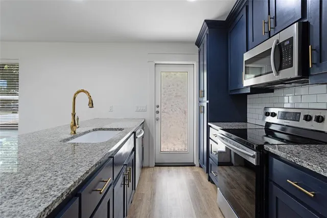 a kitchen with stainless steel appliances granite countertop a sink stove and refrigerator
