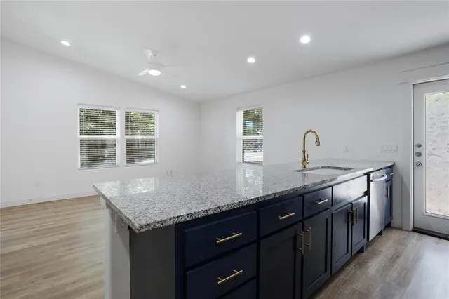 a kitchen with stainless steel appliances granite countertop a sink stove and cabinets