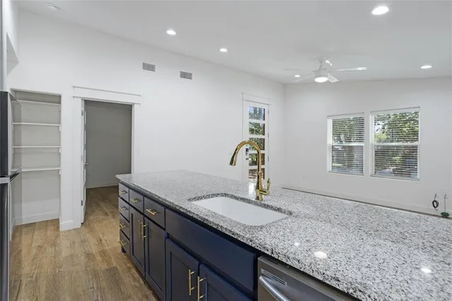 a kitchen with granite countertop kitchen island a sink and a stove