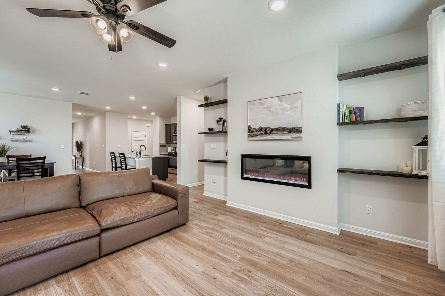 148 Gullivers Drive Elgin, TX 78621 - Photo 6 of 21 Living room with recessed lighting, a ceiling fan, light wood-type flooring, and a glass covered fireplace