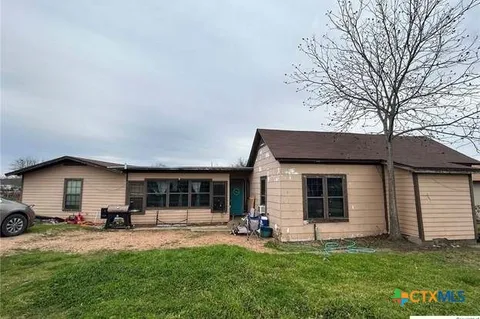 a view of a house with a yard and sitting area
