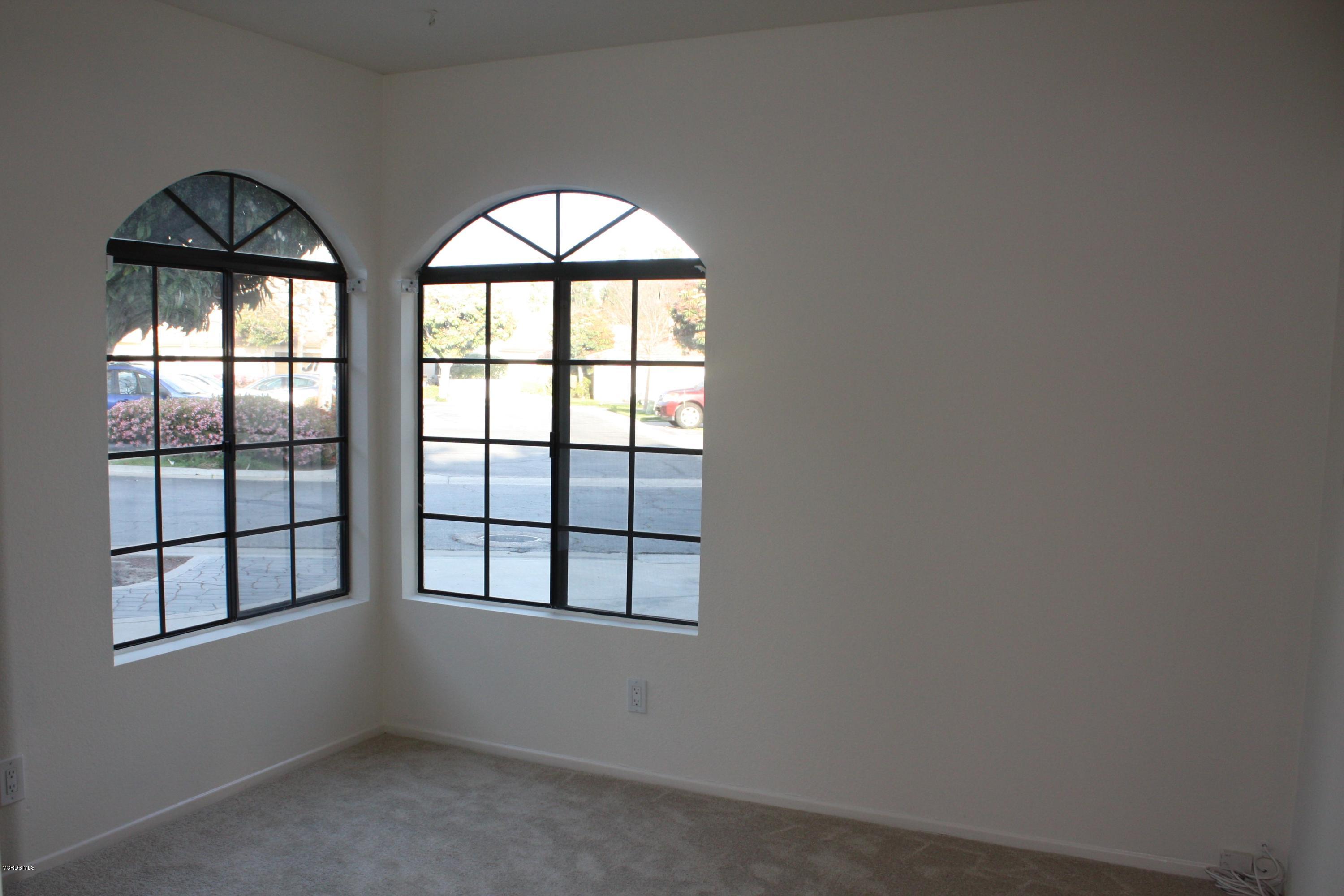 2711 Simi Hills Lane Simi Valley, CA 93063 - Photo 6 of 20 an empty room with windows and chandelier fan