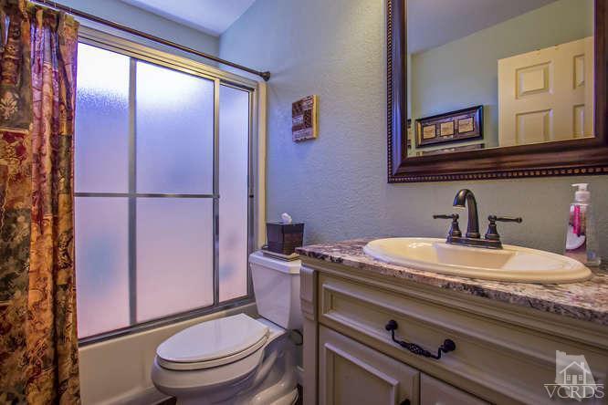 2711 Simi Hills Lane Simi Valley, CA 93063 - Photo 7 of 20 a bathroom with a granite countertop toilet sink and mirror