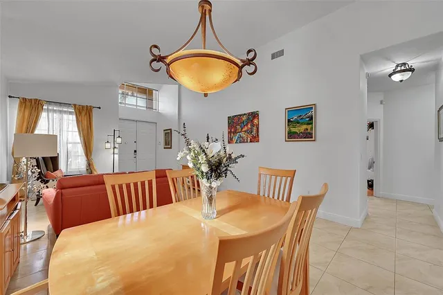 a kitchen with stainless steel appliances granite countertop a stove top oven a sink a refrigerator and white cabinets