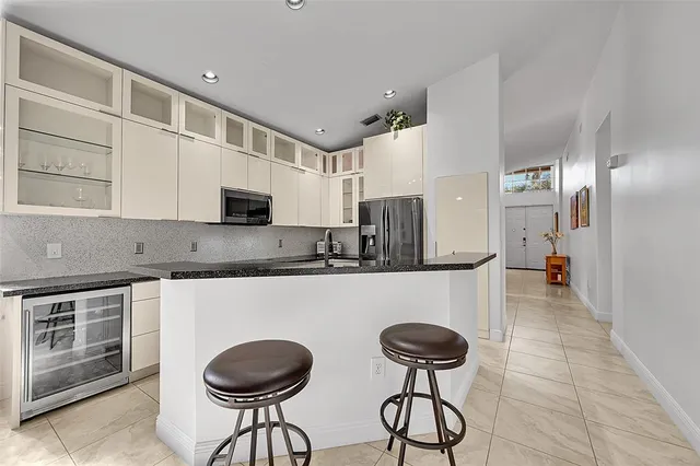 a kitchen with stainless steel appliances granite countertop a sink a stove a refrigerator and cabinets