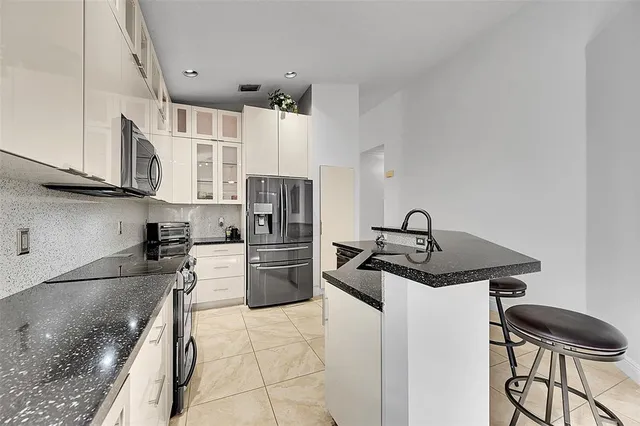 a kitchen with a sink a table and chairs in it