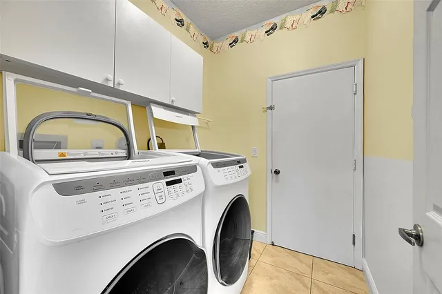 a front view of a house with garden and trees