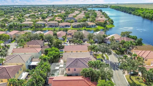 an aerial view of residential houses with outdoor space and lake view