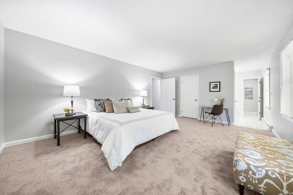 35 Old Village Road Sturbridge, MA 01566 - Photo 27 of 39 a spacious bedroom with a bed and a chandelier