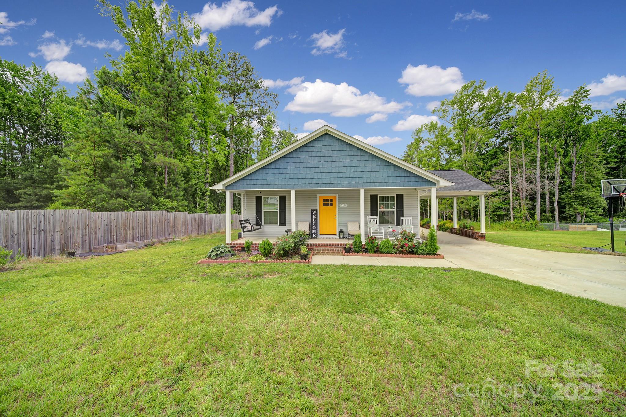 a view of a house with a yard and sitting area