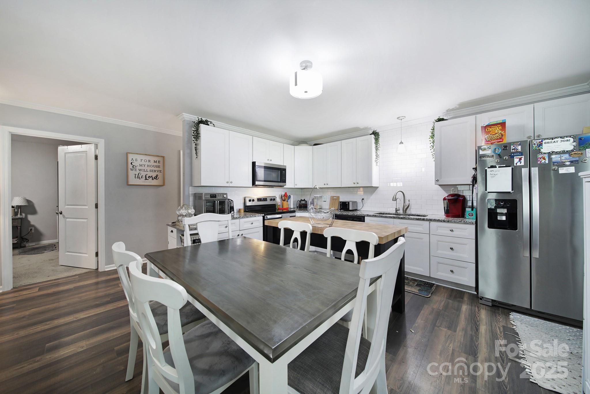2302 Douglas Road Lancaster, SC 29720 - Photo 12 of 30 a kitchen with white cabinets stainless steel appliances and dining table