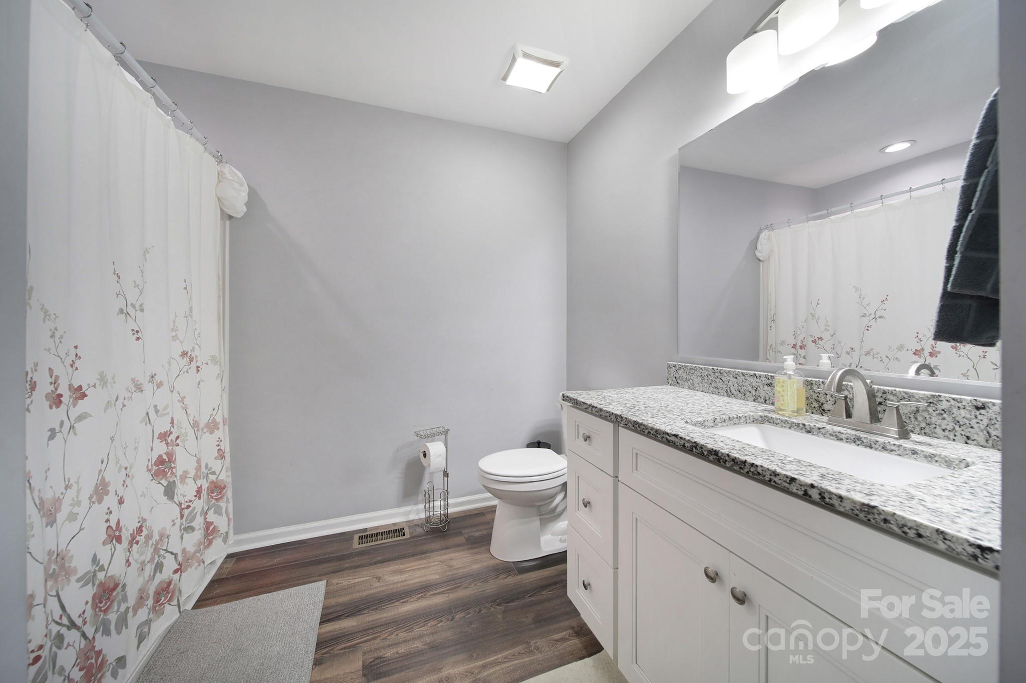 2302 Douglas Road Lancaster, SC 29720 - Photo 23 of 30 a bathroom with a granite countertop sink a toilet and a mirror