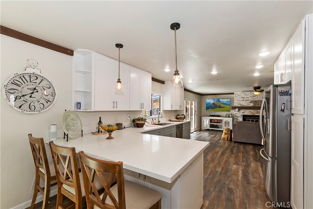 120 Pine Ridge Road Crestline, CA 92325 - Photo 19 of 58 a kitchen with stainless steel appliances a stove a sink a kitchen island with chairs and cabinets