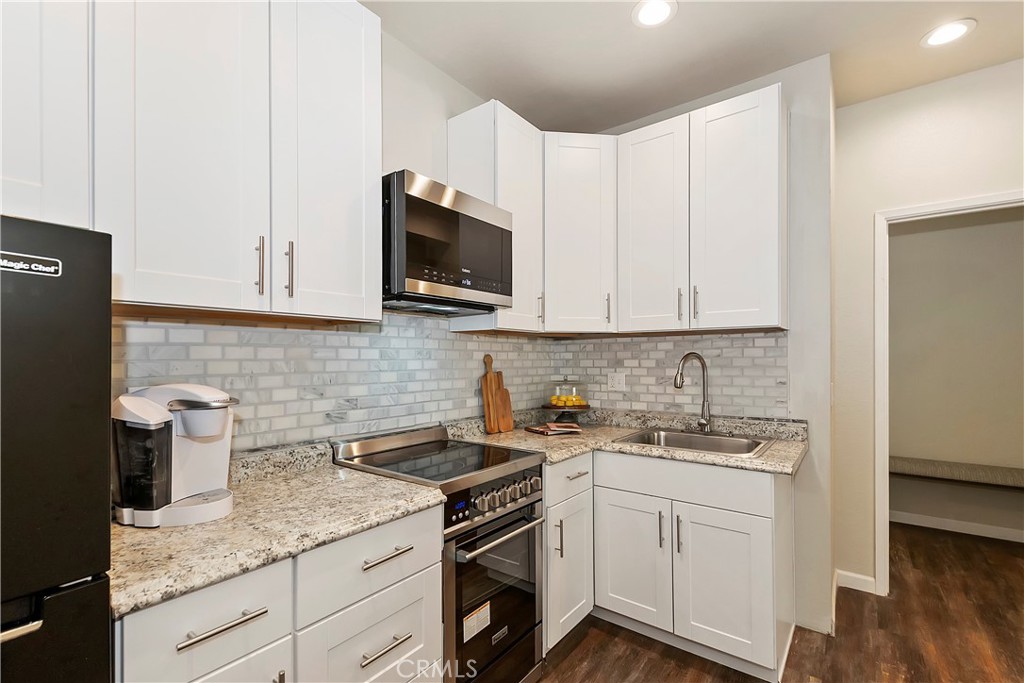 120 Pine Ridge Road Crestline, CA 92325 - Photo 44 of 58 a kitchen with stainless steel appliances granite countertop a sink a stove a microwave and cabinets