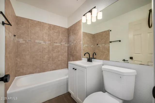 a bathroom with a toilet a sink a mirror and bathtub