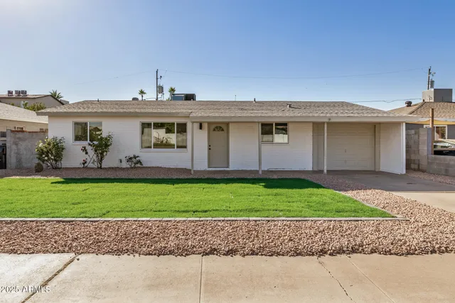 a front view of a house with a yard and a garage