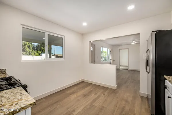 a view of a kitchen with wooden floor and a refrigerator