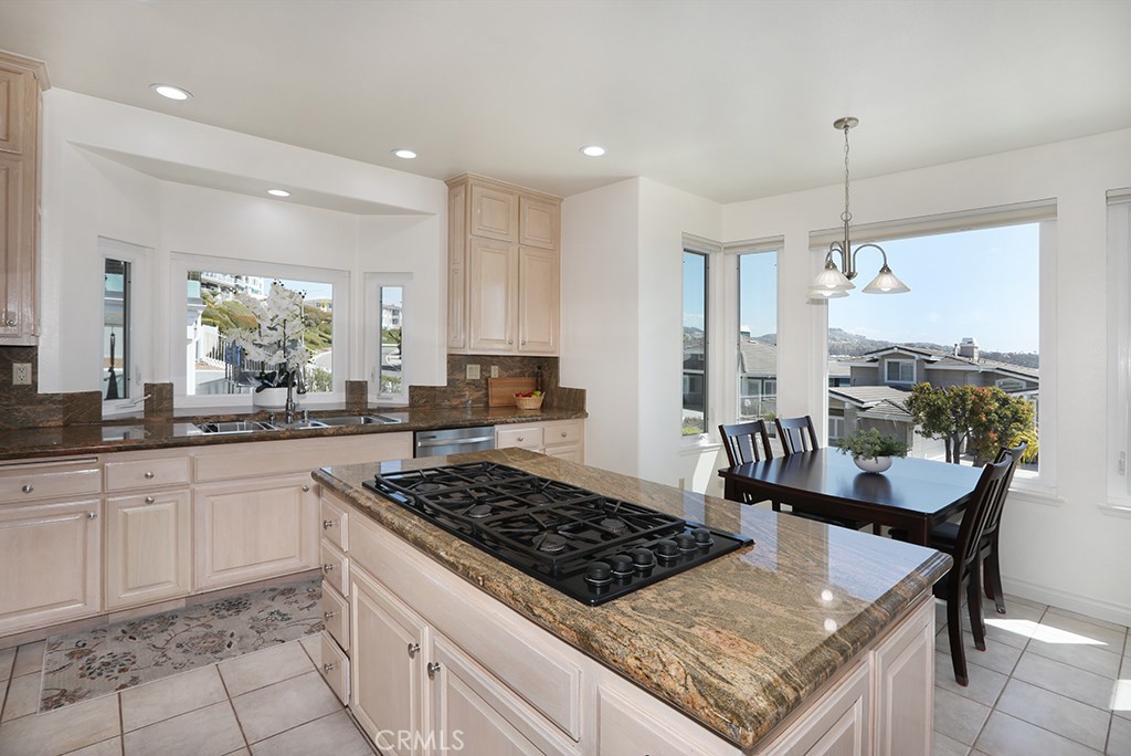 34072 Capistrano By The Sea Dana Point, CA 92629 - Photo 16 of 68 a kitchen with a stove a sink a refrigerator and chairs