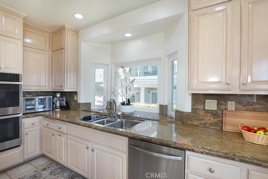 34072 Capistrano By The Sea Dana Point, CA 92629 - Photo 20 of 68 a kitchen with stainless steel appliances granite countertop a sink a stove and white cabinets
